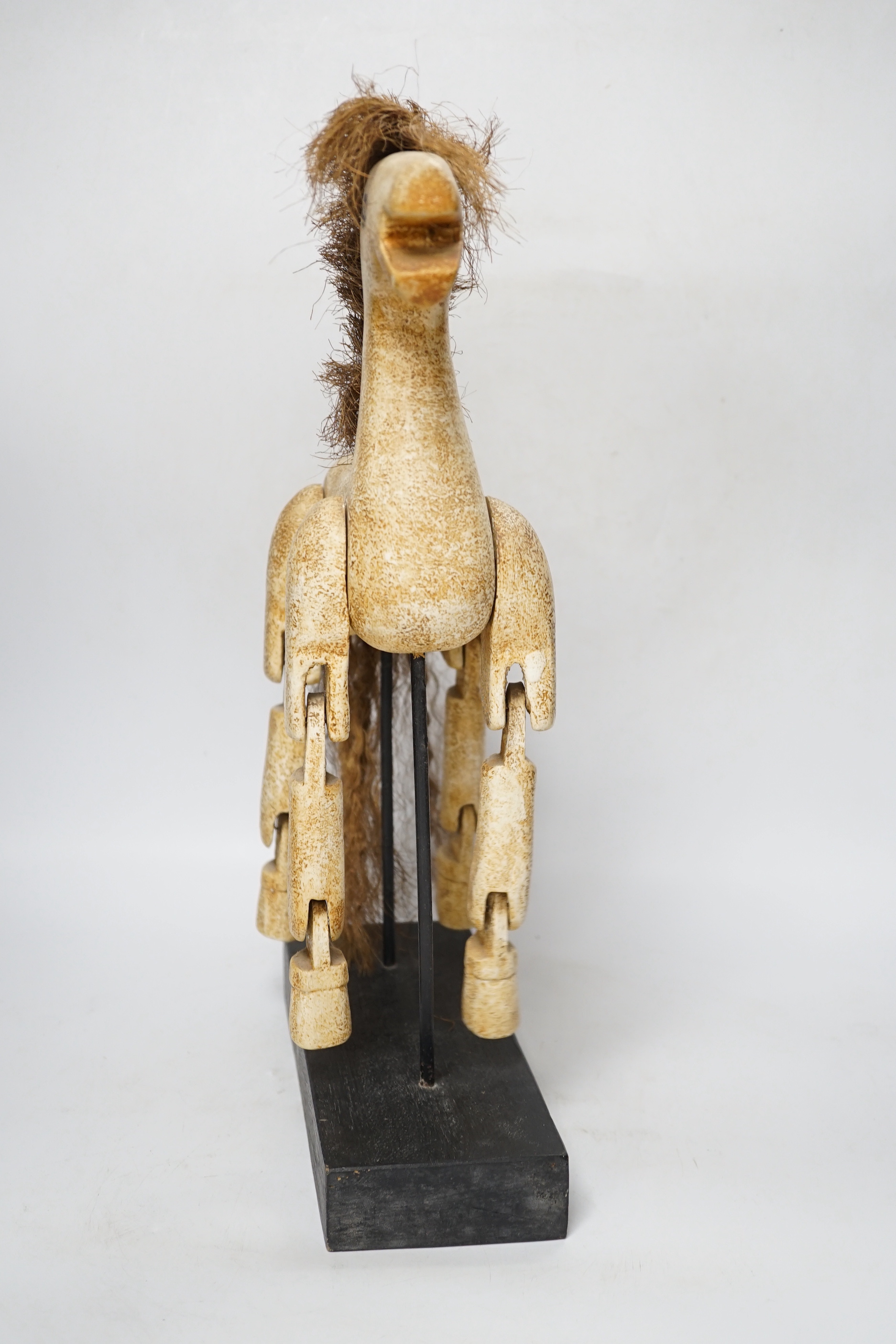 A painted, carved wood articulated model horse on stand, 42cm